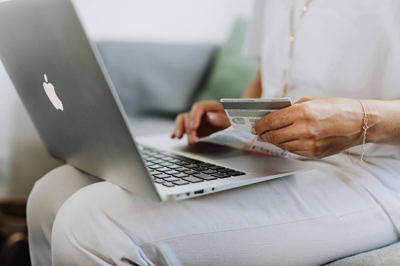 Person at a laptop with payment card, planning website spend